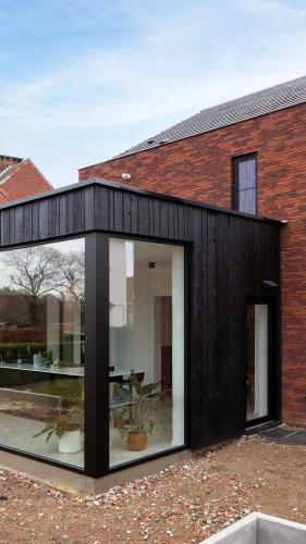 houtskeletbouw-aanbouw-natuurlijk-licht-grote-ramen-houten-gevelbekleding-afgewerkte-woning (1)